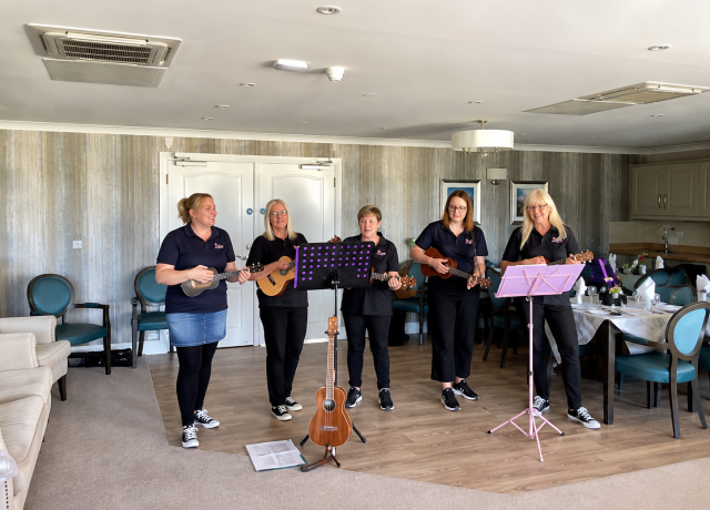 Live musicians performing with ukuleles for residents at Holbeach Meadows Care Home in Holbeach, Lincolnshire.
